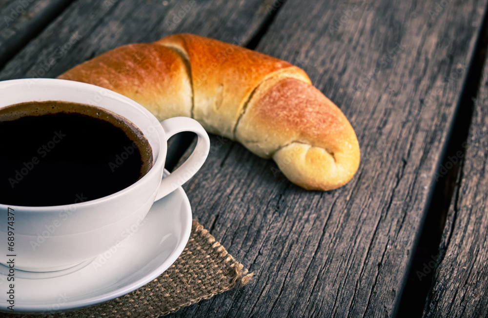 Coffee cup with a croissant breakfast Coffee cup with a croissant breakfast