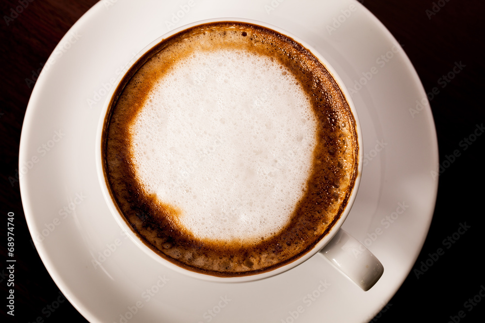 Cup of cappuccino or latte coffee on wood.
