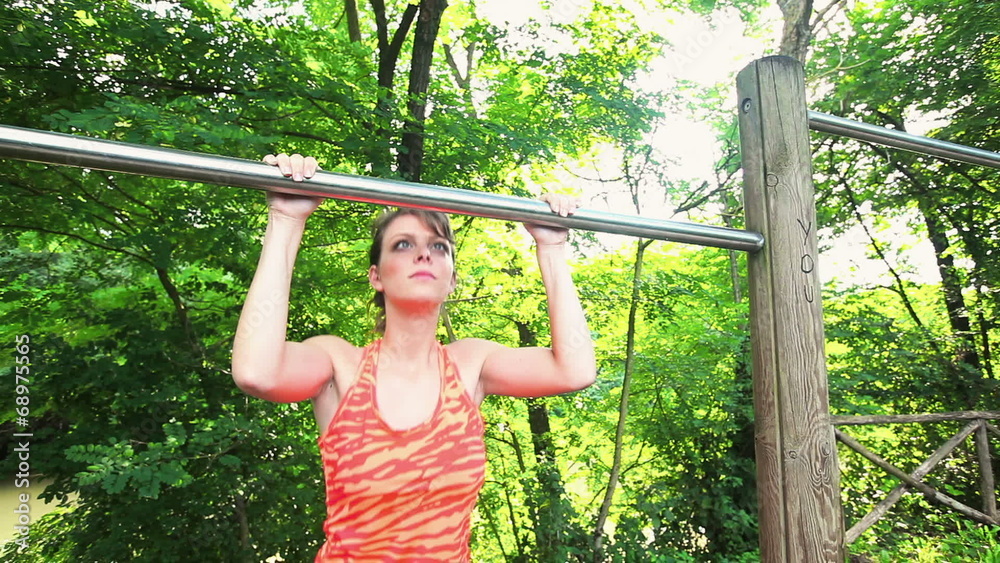 Beautiful Young Woman Doing Chin-Up Excercises Beautiful Young Woman Doing Chin-Up Excercises