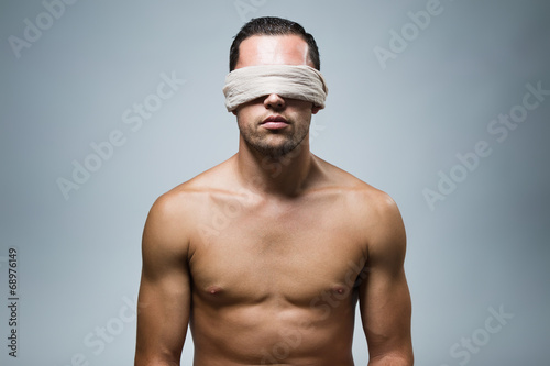 Canvas Print Portrait of young naked blindfold man.