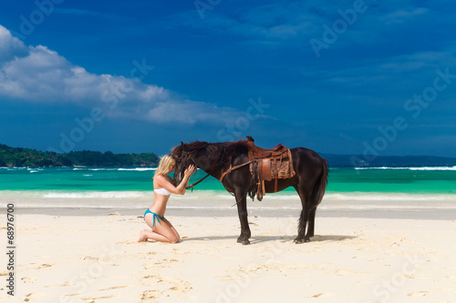 happy girl walking with horse on a tropical beach