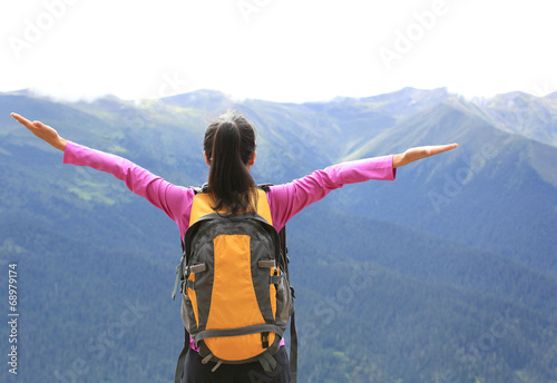 cheering young woman hiker open arms mountain peak 