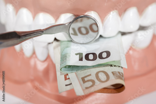 Demo Gebiß mit Geldscheinen und Zahnarztspiegel photo