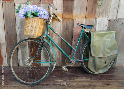 Old ladies bicycle leaning against a wooden plank photo