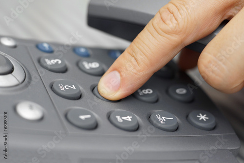 closeup of man finger is dialing a telephone number