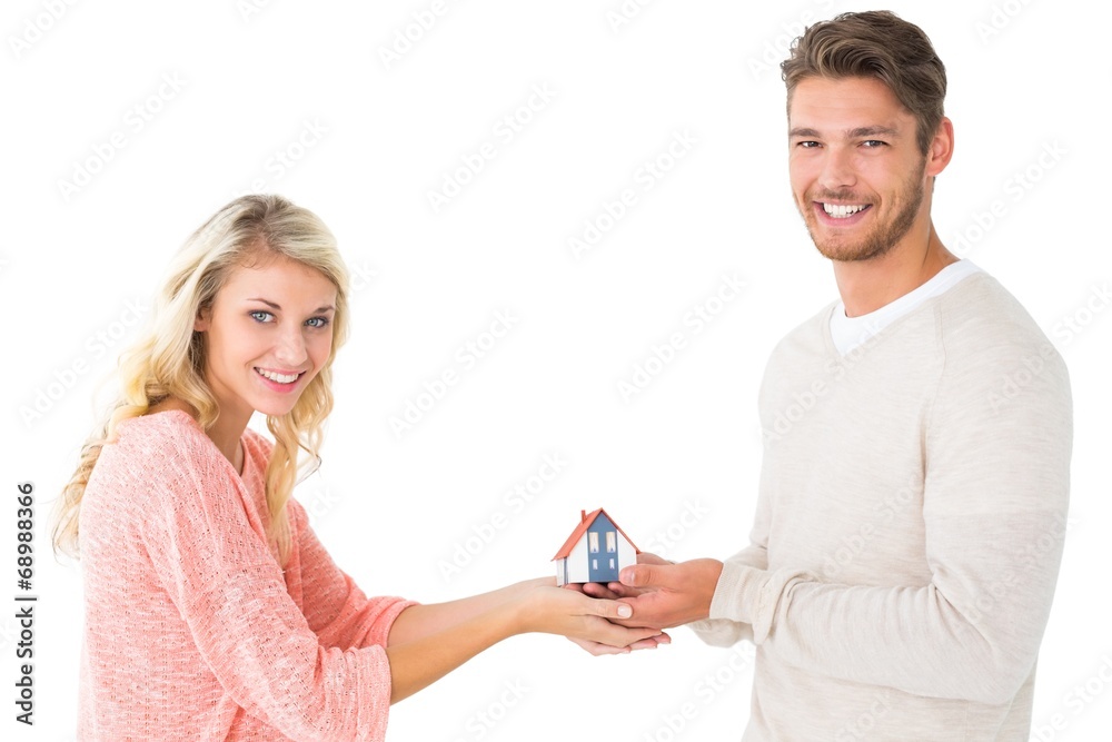 Attractive couple holding miniature house model Attractive couple holding miniature house model
