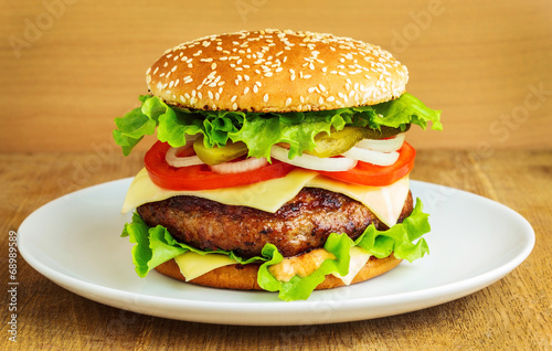 Burger in a white plate on wooden table