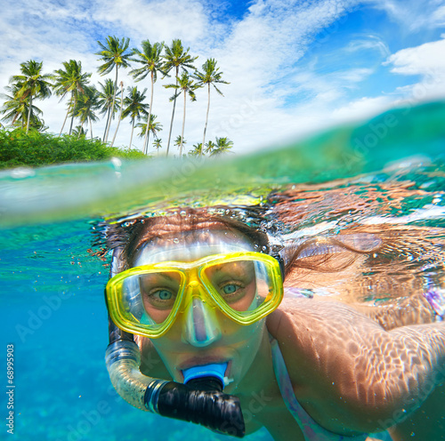 Woman with mask snorkeling in clear water