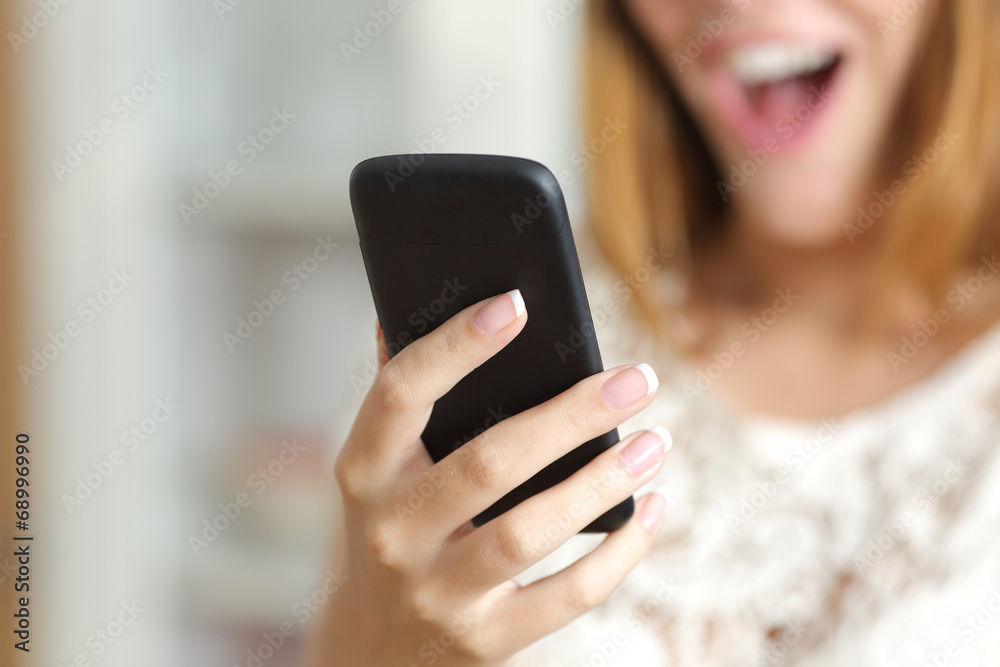 Close up of a surprised woman using a smart phone at home