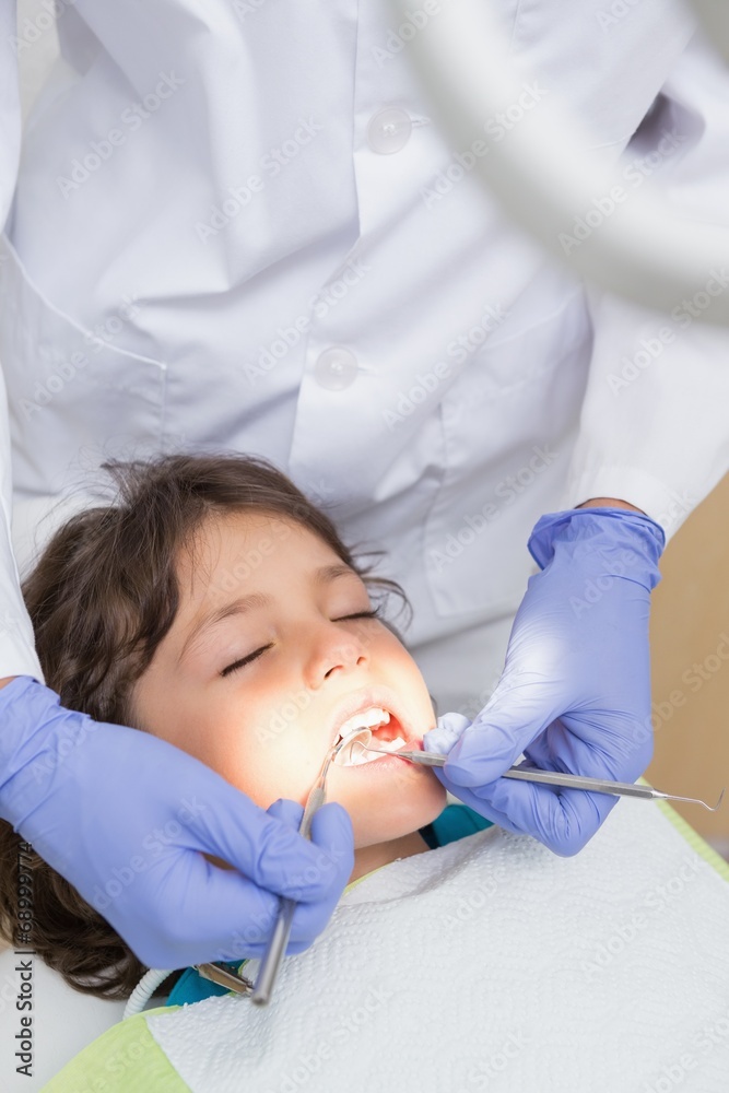 Pediatric dentist examining a little boys teeth - obrazy, fototapety, plakaty 