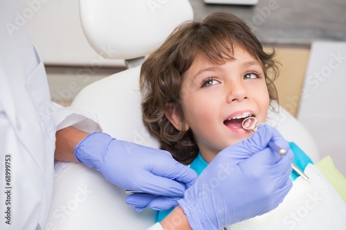 Pediatric dentist examining a little boys teeth photo