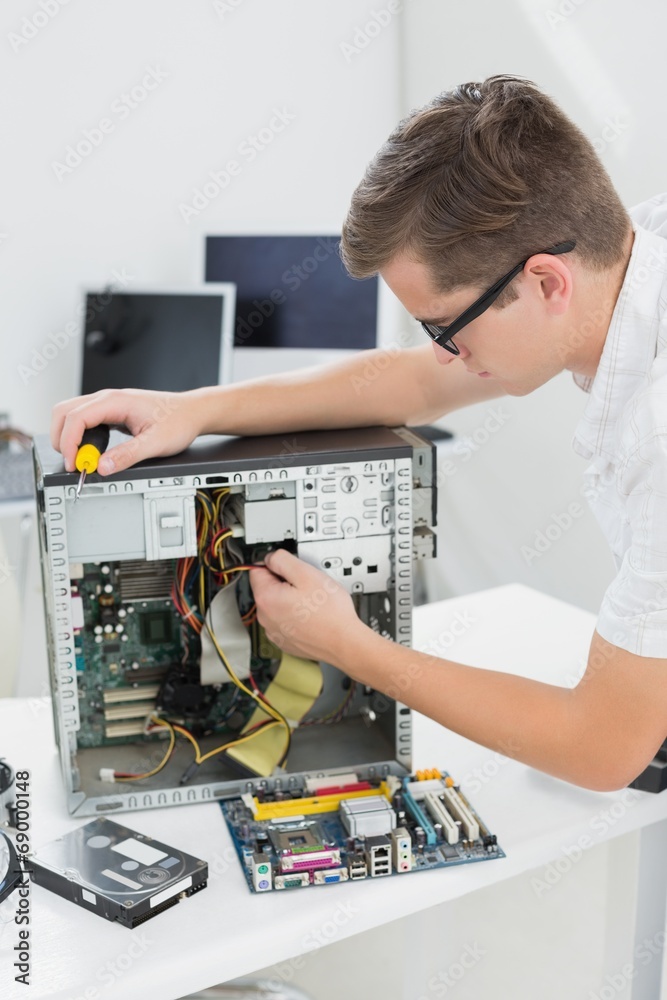 Obraz premium Young technician working on broken computer