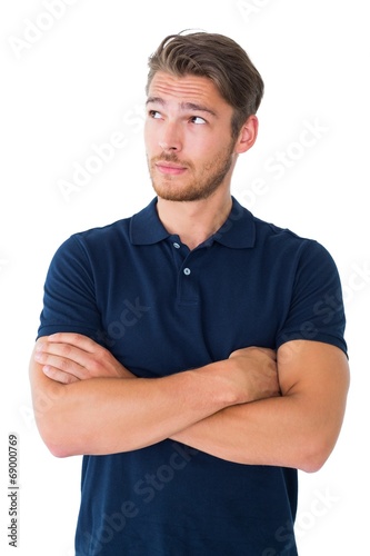 Handsome young man thinking with arms crossed