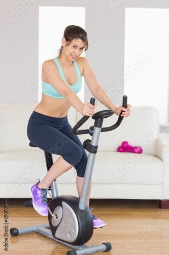 Fit brunette working out on exercise bike