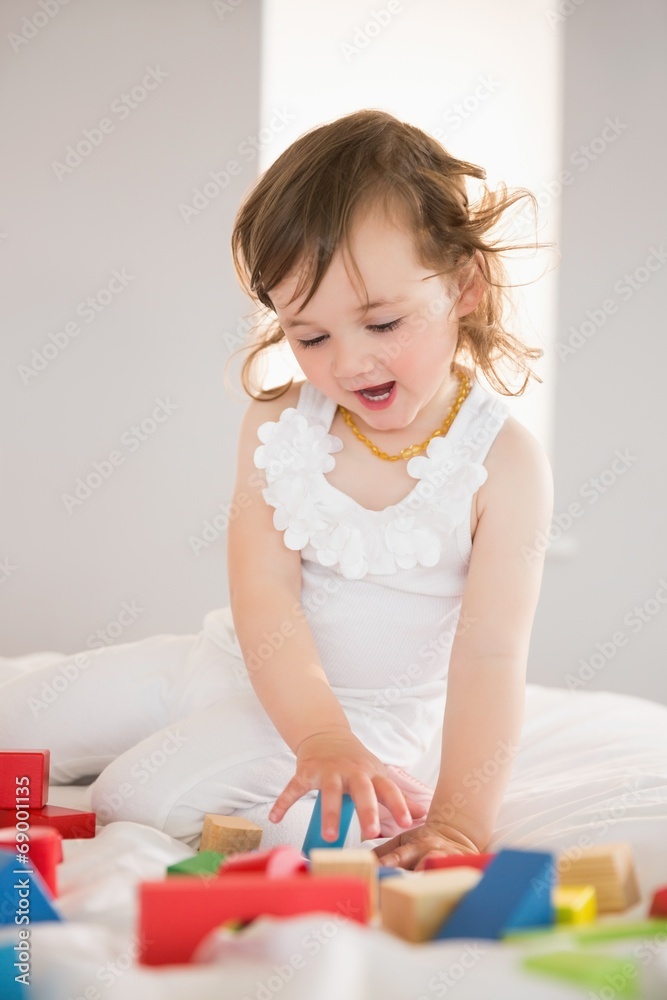 Cute girl playing with building blocks on bed Cute girl playing with building blocks on bed