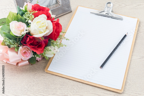 Wooden Clipboard attach planning paper with pencil beside rose b