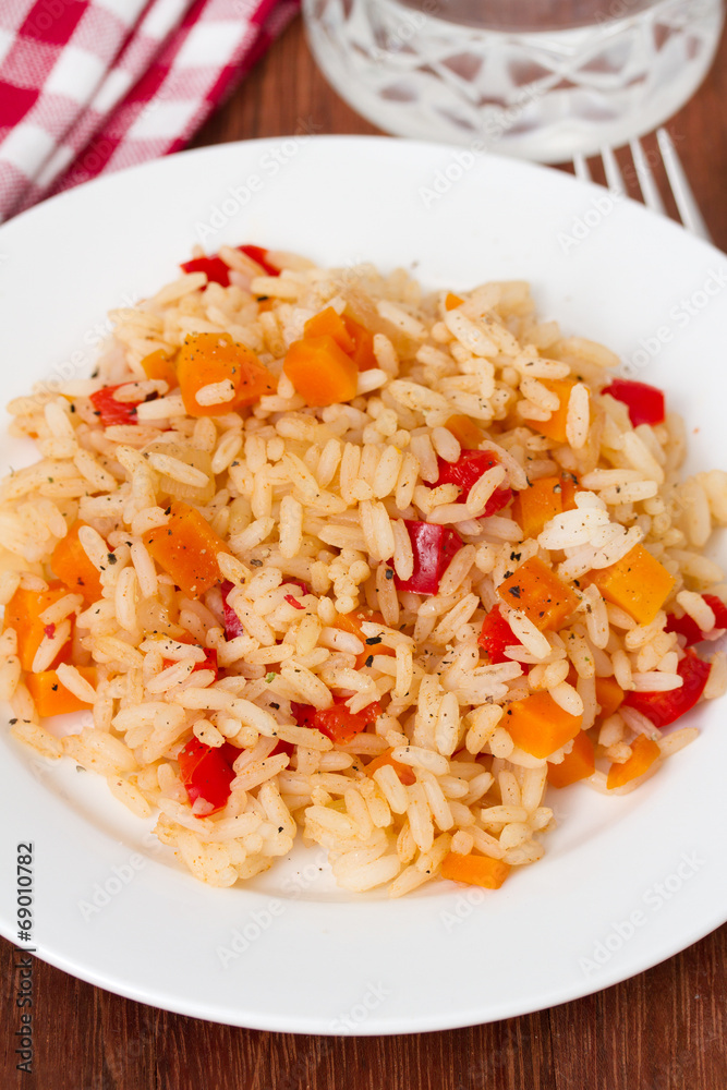 rice with vegetables on plate and glass of water rice with vegetables on plate and glass of water