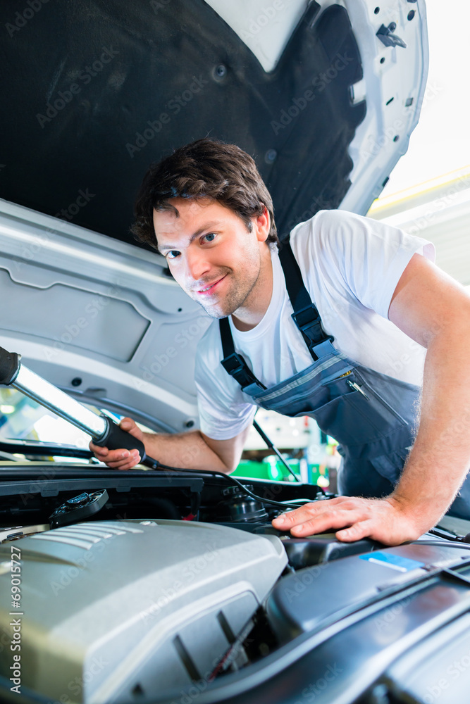 KFZ-Mechaniker arbeitet in Autowerkstatt KFZ-Mechaniker arbeitet in Autowerkstatt