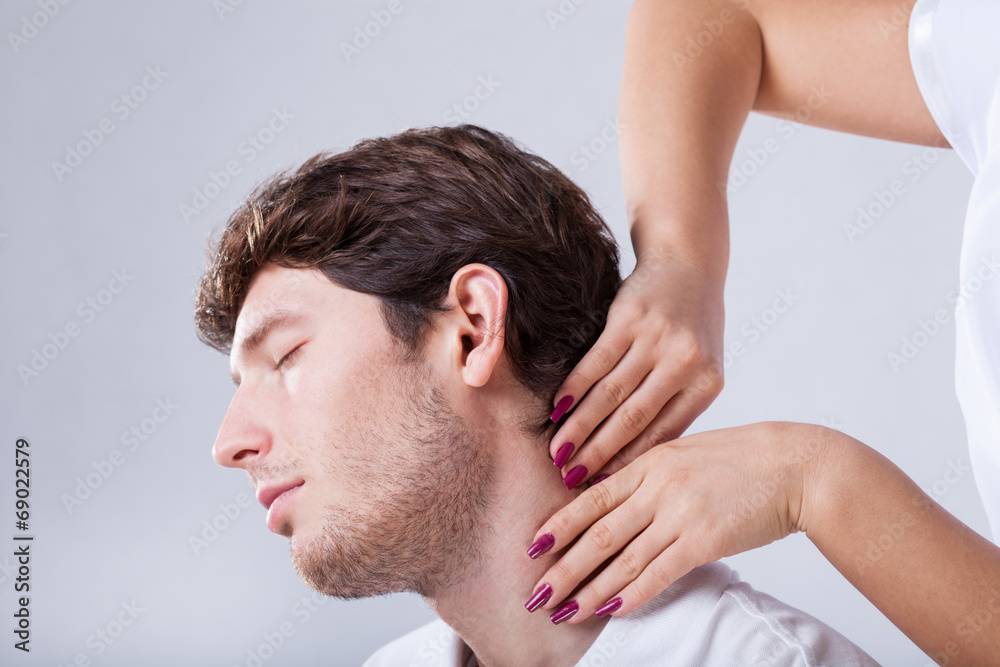 Obraz premium Physiotherapist palpationing patient with stiff neck