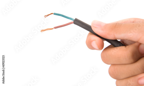 Female hand holding exposed electrical wire over white 