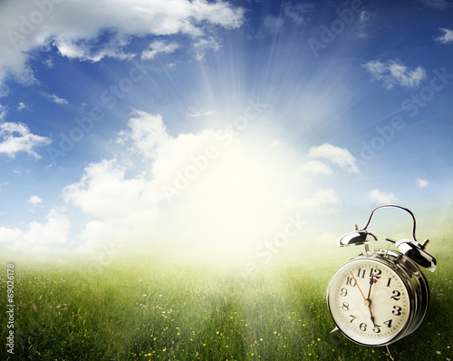 Alarm clock in field. Springtime. Daylight savings