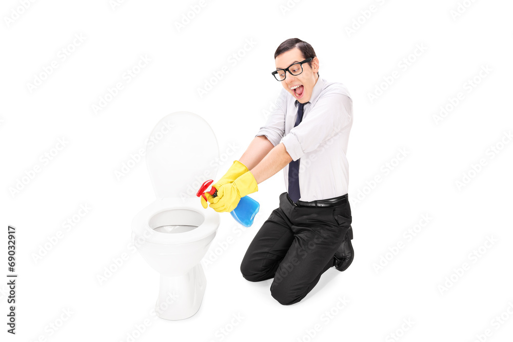 Man cleaning a toilet with disinfecting spray Man cleaning a toilet with disinfecting spray