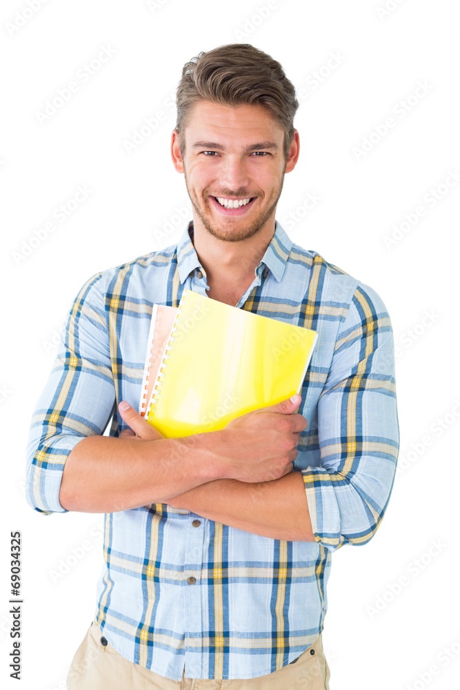 Handsome student holding notepad smiling at camera Handsome student holding notepad smiling at camera