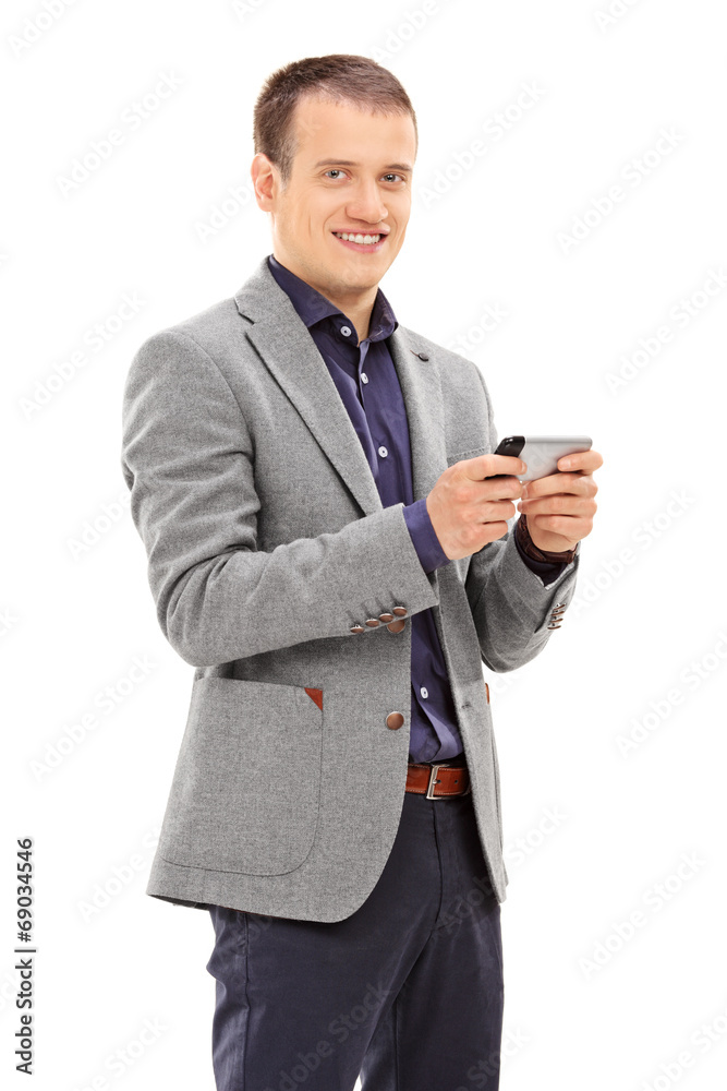 Young man typing a message on his cell phone Young man typing a message on his cell phone