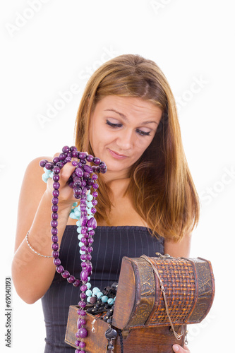 undecided girl takes out jewelery from jewelry box