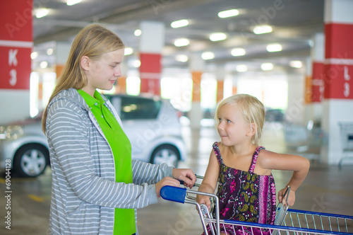 Young mother and adorable daughter in shopping cart on undergrou photo