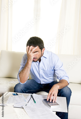 latin business man worried paying bills on couch