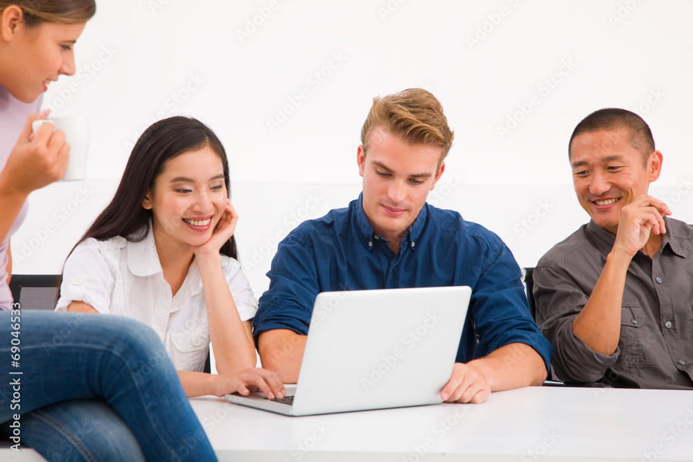 Multi ethnic group of executives looking laptop Multi ethnic group of executives looking laptop