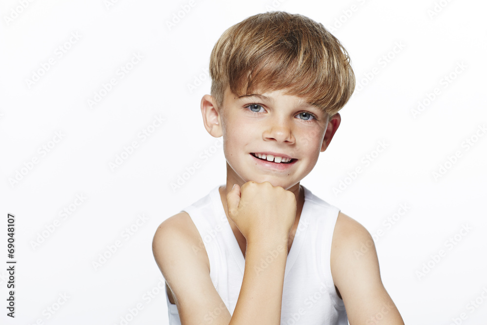 Portrait of young boy in vest, studio.