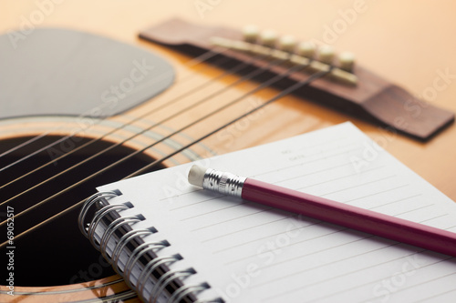 Notebook and pencil on guitar photo