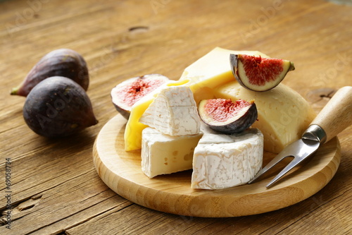 Fotografi cheeseboard with maasdam, camembert, cheddar cheese and figs