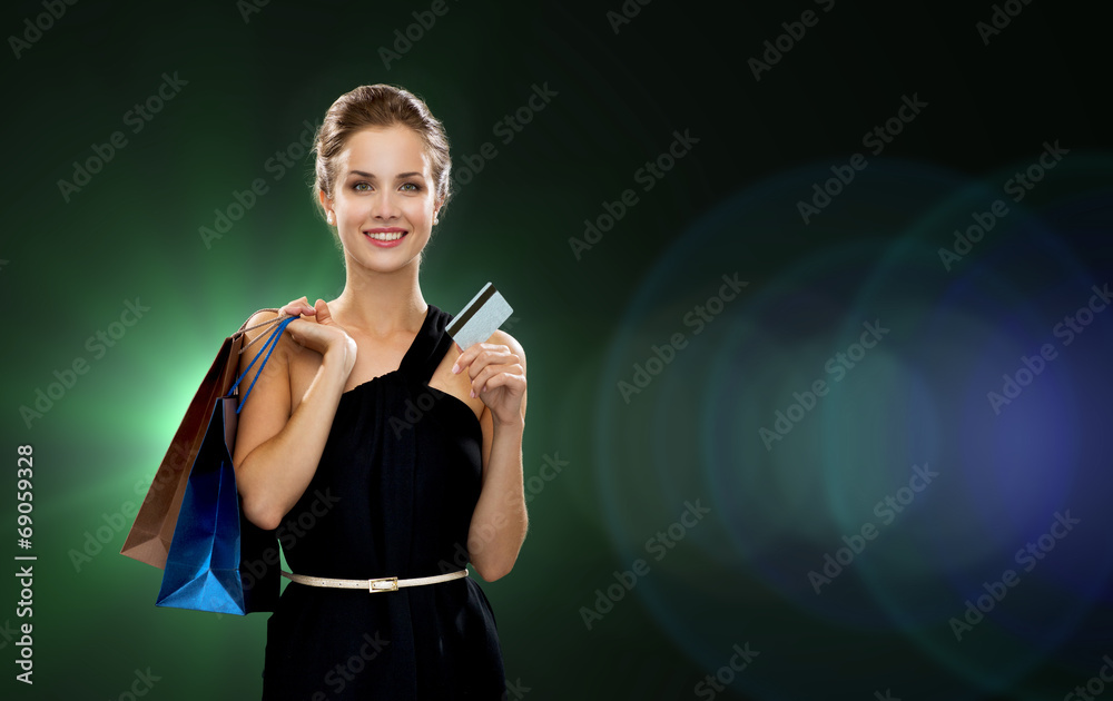 smiling woman with shopping bags and credit card
