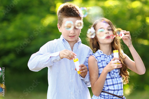 Portrait of a boy girl in a summer with bubble