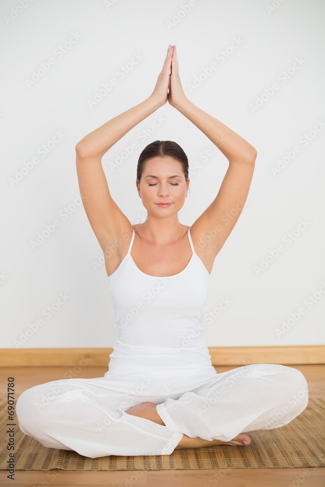 Peaceful brunette sitting and meditating in lotus pose Peaceful brunette sitting and meditating in lotus pose