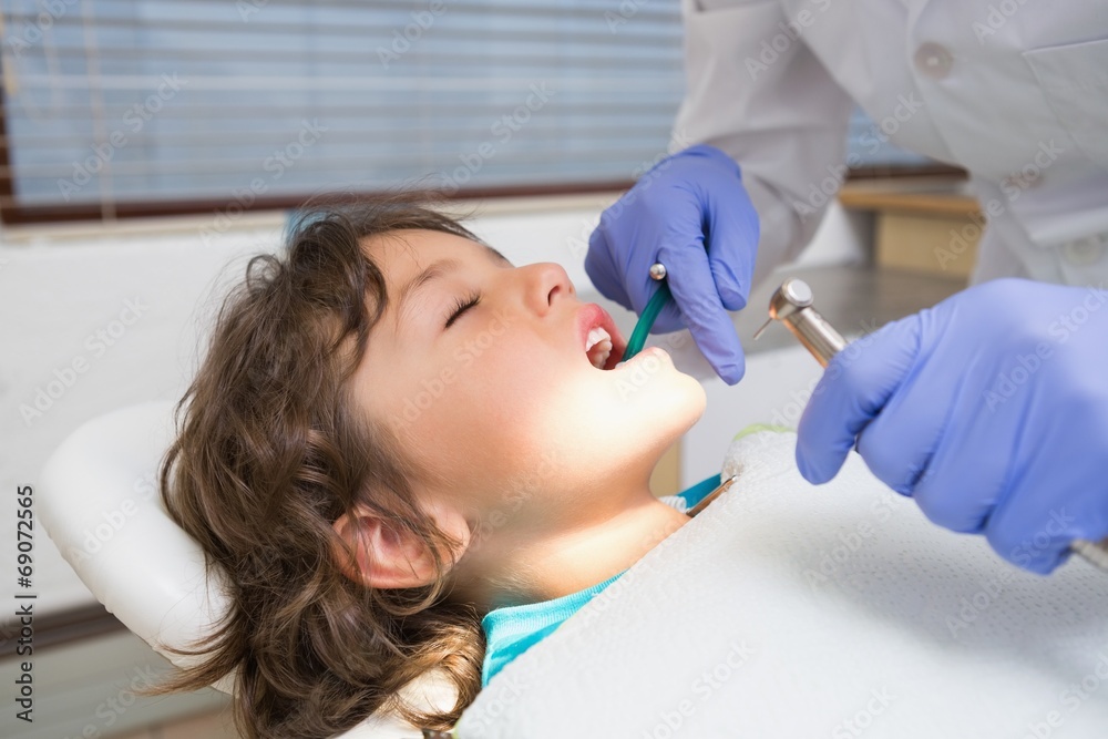 Pediatric dentist examining a little boys teeth Pediatric dentist examining a little boys teeth