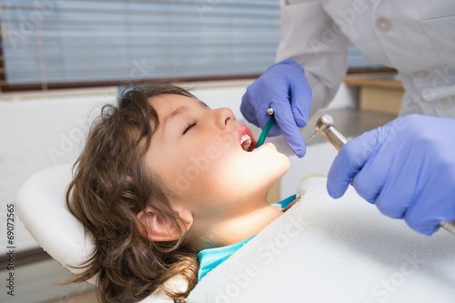 Pediatric dentist examining a little boys teeth