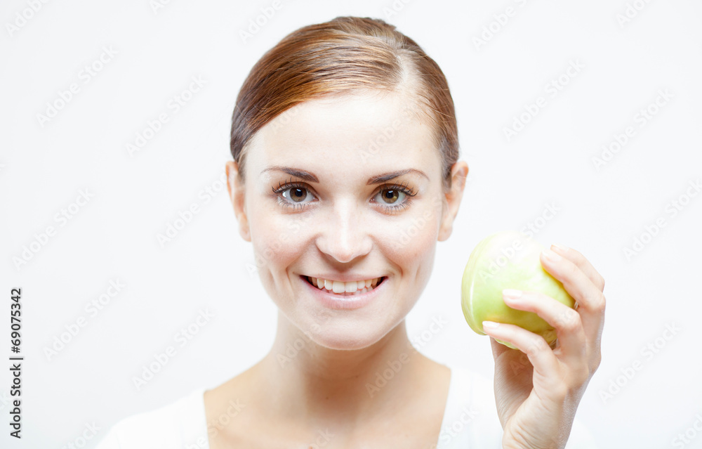 Smiling woman holding and eating green apple Smiling woman holding and eating green apple
