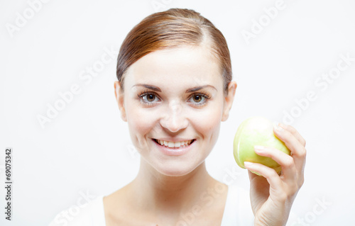 Smiling woman holding and eating green apple