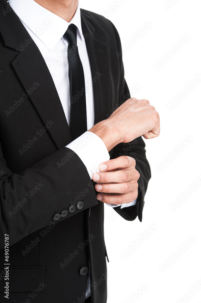Detail of young businessman adjusting his sleeve.