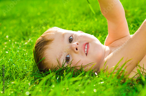 Portrait of beautiful boy lying on the grass
