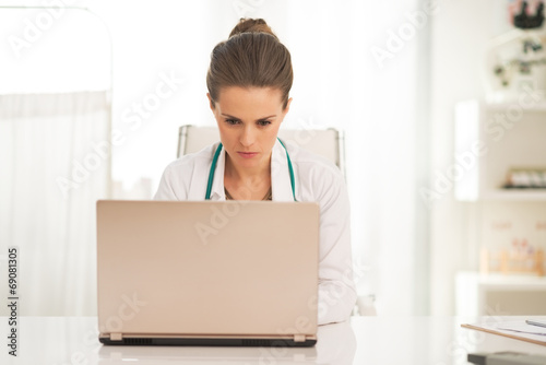 Doctor woman working on laptop in office