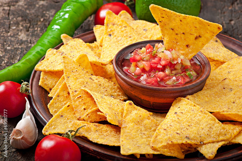 Obraz na plátně Mexican nacho chips and salsa dip in bowl on wooden background