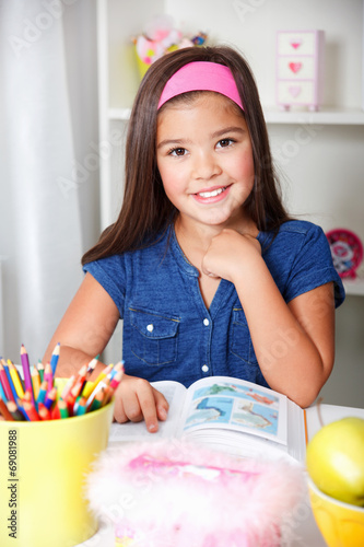 Close-up portrait of a beautiful young school girl reading a boo