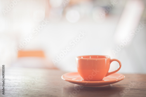 Mini orange coffee cup on wooden table