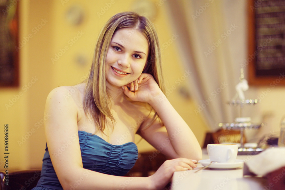 young woman in a cafe, drinking tea young woman in a cafe, drinking tea