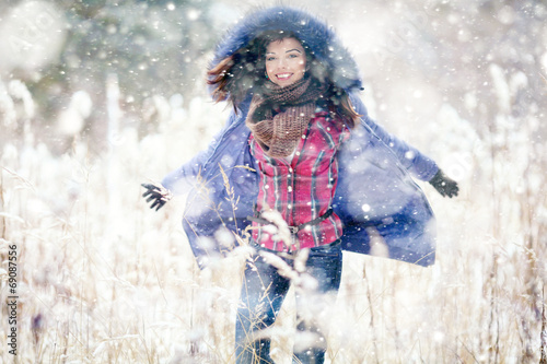 Girl having fun and jumping in the snow